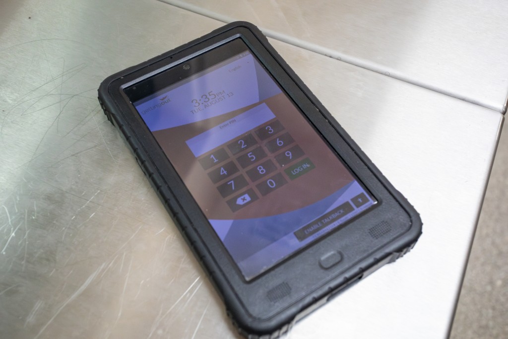 A tablet computer in a black rubber case displays a number pad.